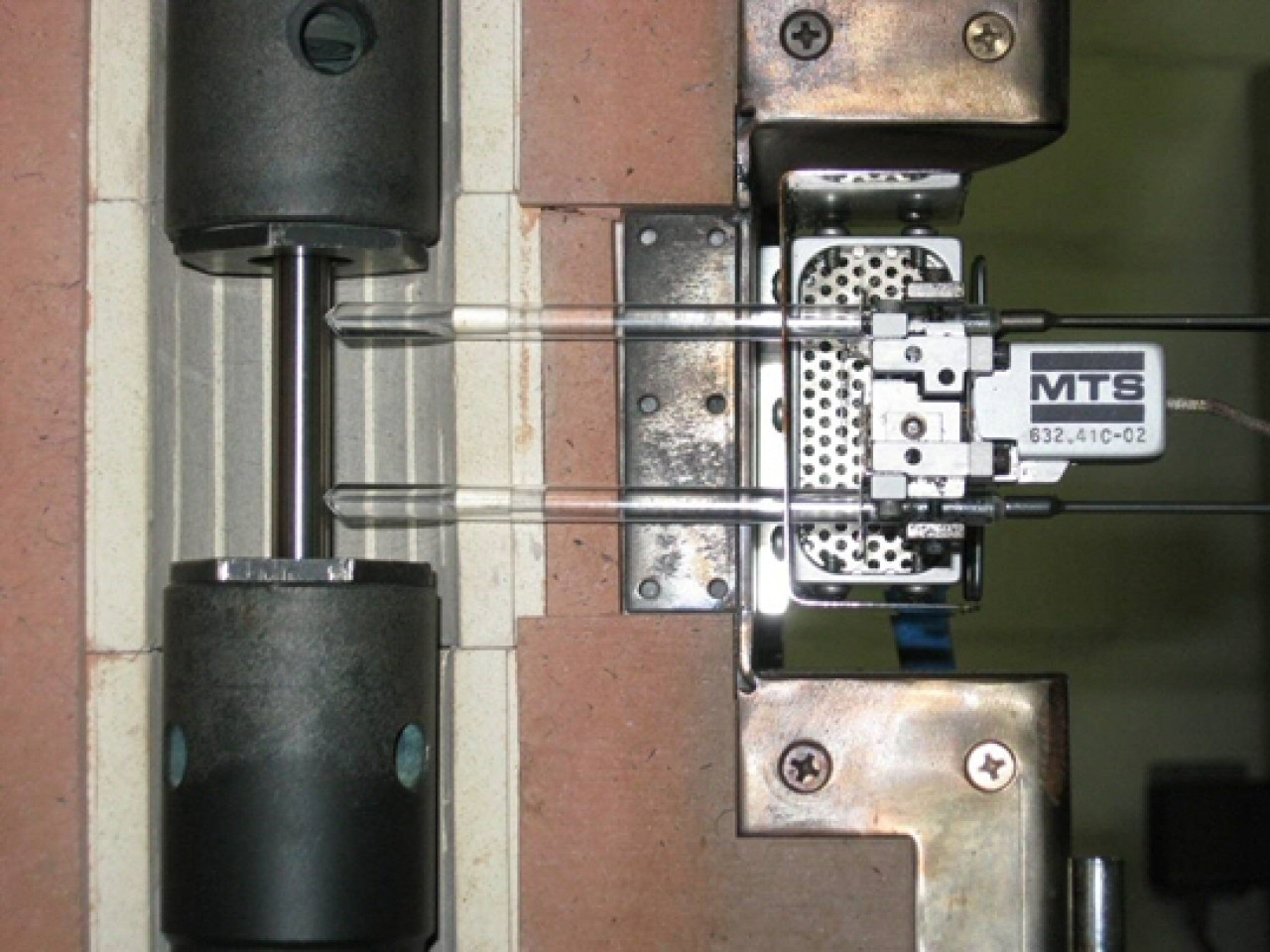 Prova di trazione ad alta temperatura su campione metallico, strumentato con estensometro per la misura delle deformazioni Prova di trazione ad alta temperatura su campione metallico, strumentato con estensometro per la misura delle deformazioni